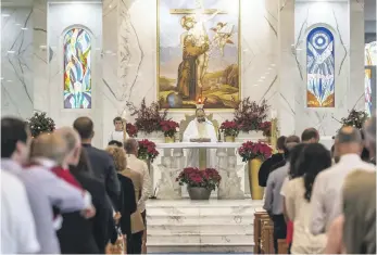  ?? Antonie Robertson / The National; EPA ?? Above, Christmas Day Mass at St Francis of Assisi Church in Jebel Ali; left, a nun prays in St Joseph’s Catholic Cathedral in Abu Dhabi