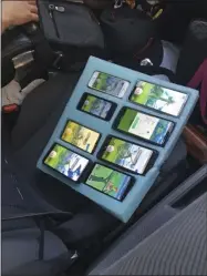  ?? KYLE SMITH - ASSOCIATED PRESS ?? In this Aug. 13photo provided by the Washington State Patrol, a piece of foam, cut to hold eight mobile phones in place — all of them playing the game Pokemon Go — is shown on the passenger seat of a vehicle driven by a person who was found pulled over on the shoulder of a highway in Washington state near Seattle by a Washington state trooper who thought the driver needed assistance.