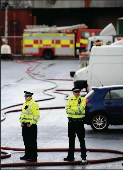  ??  ?? Police officers were at the scene at the market in Blochairn following Thursday’s huge fire
