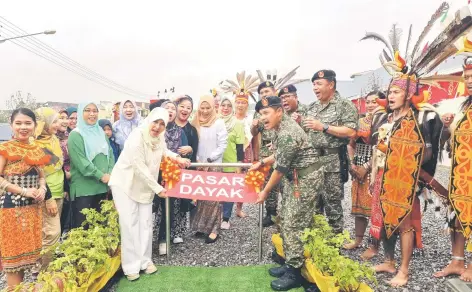  ?? ?? Mohd Sofi (front right) performs the symbolic opening of the renovated Penrissen Army Camp Dayak Market.