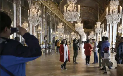  ?? AMR NABIL, FILE — ASSOCIATED PRESS FILE ?? In this Nov. 17, 2015, file photo, visitors pose inside the Hall of Mirrors in the Versailles castle in Versailles, west of Paris. Rick Steves’ summer travel tips include getting tickets in advance for major attraction­s so you can skip the line and avoid the crowds, and following local cultural customs to beat the heat, such as taking an afternoon siesta or dining late in the evening when it’s cooler.