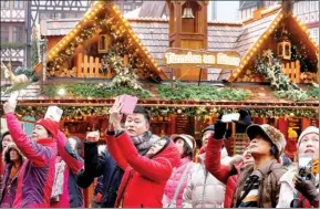  ?? AP ?? Chinese tourists take pictures of the Christmas market in Frankfurt, Germany,