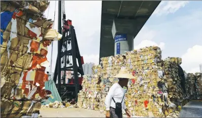  ?? ROY LIU / CHINA DAILY ?? Paper and cardboard pile high at Rambler Channel Public Cargo Working Area in Kwai Chung on Friday as recyclers suspended waste-paper collection after mainland authoritie­s moved to tighten restrictio­ns on waste imports.