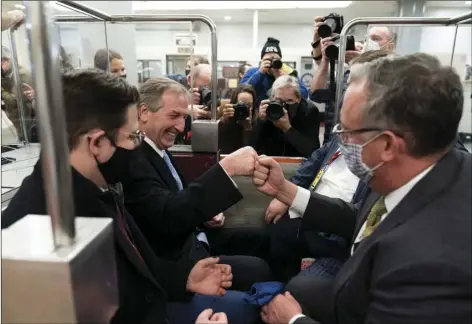  ?? AP PHOTO/ALEX BRANDON ?? Michael van der Veen (second from left) an attorney for former President Donald Trump, fist bumps a colleague as the depart on the Senate Subway, on Capitol Hill after the Senate acquitted Trump in his second impeachmen­t trial in the Senate at the U.S. Capitol in Washington, on Saturday.