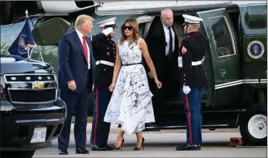  ??  ?? President Donald Trump, accompanie­d by first lady Melania Trump, step off Marine One on July 3 as they arrive at Mount Rushmore National Memorial near Keystone, S.D. Stories circulatin­g online incorrectl­y asserted the dress Melania Trump wore during Fourth of July celebratio­ns featured drawings by various victims of child sex traffickin­g. The sketches on the dress were made by design students from the British art school Central Saint Martins.
(File photo/AP/Alex Brandon)