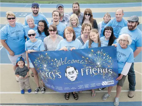  ?? DAX MELMER ?? Mary Slavik, centre, is surrounded by friends and family of the late Jerry Slavik at Alumni Field on Friday. Jerry’s Friends, an event in tribute to Slavik, is being held there on Saturday evening.