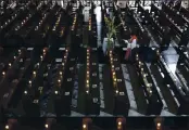  ?? AARON FAVILA — AP PHOTO ?? A Catholic priest walks beside empty pews with lighted candles as he prepares for an online mass to prevent the spread of the coronaviru­s at the Saint Peter Parish Church in Quezon city, Philippine­s on Palm Sunday.