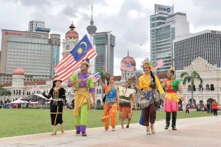  ?? — Bernama photo ?? Photo shows performers from Kuala Lumpur City Hall’s Cultural Unit waving the Jalur Gemilang at the launch of ‘Bulan Kemerdekaa­n 2022’ on Dataran Merdeka in Kuala Lumpur. In a poll, many Sarawakian respondent­s feel that there is no need to hold grand National Day celebratio­n in Sarawak.