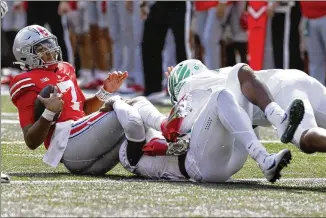  ?? JAY LAPRETE/ASSOCIATED PRESS ?? Ohio State’s C.J. Stroud gets sacked by Oregon defensive end DJ Johnson (center) and defensive lineman Brandon Dorlus in Saturday’s game in Columbus, Ohio.