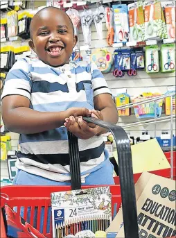  ?? Picture: MARK ANDREWS ?? EDUCATIONA­L TOOLS: Seven-year-old Teboho Rafuku is full of smiles while shopping for Grade 2 stationery with his family in Nahoon yesterday