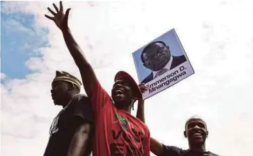  ??  ?? PELAJAR Universiti Zimbabwe memegang potret bekas Naib Presiden Emmerson Mnangagwa berarak di Harare mendesak ijazah kedoktoran isteri Mugabe, Grace, ditarik balik, selepas enggan menduduki peperiksaa­n sebagai tanda protes. - AFP