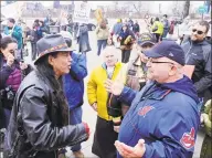  ?? Mark Duncan / Associated Press ?? Philip Yenyo, left, executive director of the American Indian Movement for Ohio, talks with a Cleveland Indians fan before a game against the Tigers in April 2015 in Cleveland.