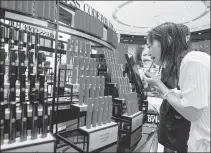  ?? WU WEI / FOR CHINA DAILY ?? A customer tries out cosmetics at a duty-free shop in Sanya, Hainan province.