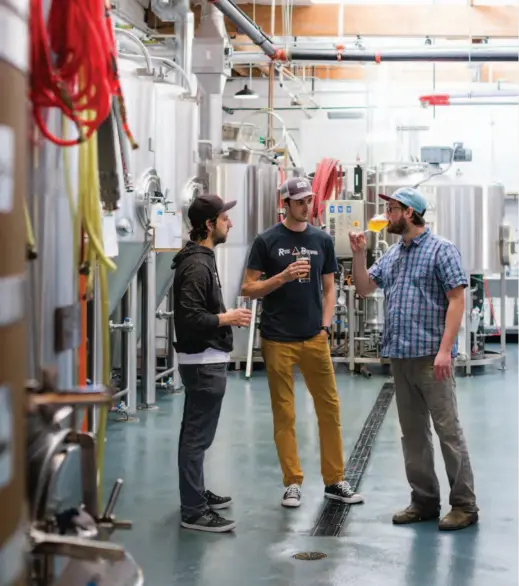  ??  ?? Above » Shaun Kalis,
Luc Goovaerts, and Devin Benware in the Ruse Brewing brewhouse and cellar.