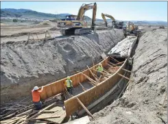  ?? Signal file photo ?? Excavators and workers create a form for a 700-foot-long, 4-foot-high by 8foot-wide storm drain as constructi­on progresses at Vista Canyon developmen­t in Canyon Country in February.