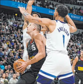  ?? David Zalubowski The Associated Press ?? Timberwolv­es center Karl-anthony Towns, rear, and forward Kyle Anderson hound Nuggets center Nikola Jokic in Minnesota’s 106-80 win Monday night at Ball Arena.