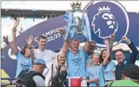  ?? (AFP) ?? Manchester City’s Norwegian striker Erling Haaland (C) lifts up the Premier League trophy as he celebrates with his family at the Etihad Stadium in Manchester on Sunday.