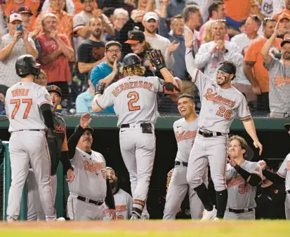  ?? JESS RAPFOGEL/AP ?? The Orioles’ Gunnar Henderson returns to the dugout and celebrates with teammates after his two-run triple during the seventh inning of Wednesday night’s 6-2 win over the Nationals. He scored on an error on the play.