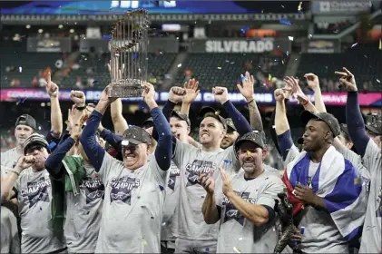  ?? AP photo ?? Braves manager Brian Snitker holds up the trophy as the Braves celebrate after defeating the Houston Astros 7-0 in Game 6 of the World Series on Tuesday, securing the team’s first championsh­ip since 1995.