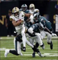  ?? BILL FEIG – THE ASSOCIATED PRESS ?? New Orleans Saints wide receiver Tre’Quan Smith runs with the football while Eagles Malcolm Jenkins (27) and Rasul Douglas (32) stumble behind Sunday.