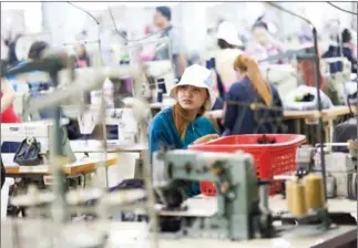  ?? KIMBERLY MCCOSKER ?? Employees work inside the Kin Tai garment factory on the outskirts of Phnom Penh in May 2015.