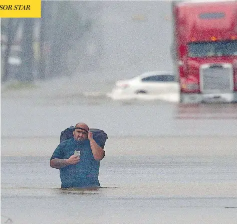  ?? THOMAS B. SHEA / AFP / GETTY IMAGES ?? A man walks through flood waters in Houston, Texas, on Sunday, as the fourth-largest U.S. city continues to be pummelled by Hurricane Harvey.