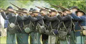  ?? NEWS-HERALD FILE ?? A group of men, representi­ng the Union Army 7th, 8th and 66th regiments, reenact firing drill practices during a Civil War Encampment at the James A. Garfield National Historic Site in Mentor in July 2014.