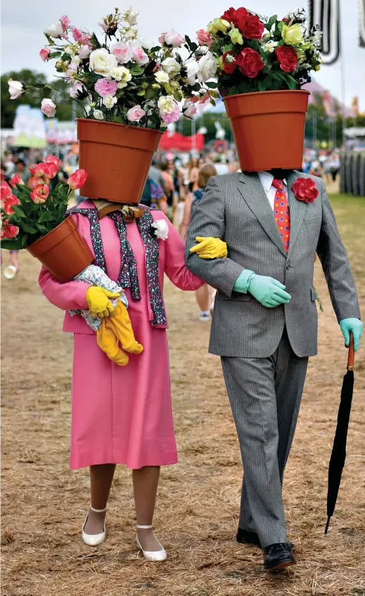  ?? ?? Flower power: This charmingly barmy couple created outfits using plastic pots and even carried a ‘flower child’