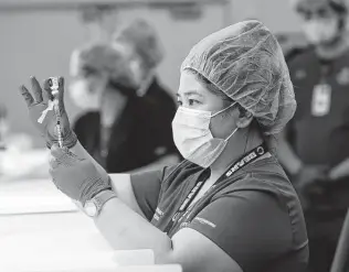  ?? Kin Man Hui / Staff photograph­er ?? Pharmacy technician Vernice Ver draws a dose of the Pfizer vaccine at University Health last month. The third vaccine approved over the weekend will speed up inoculatio­n in the area, officials said.