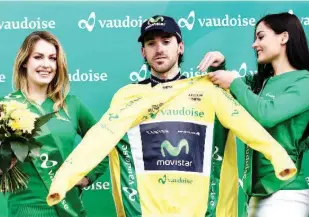  ??  ?? Spain’s Ion Izagirre (C) of Team Movistar puts on the overall leader’s yellow jersey during the podium ceremony after the first stage of the 70th Tour de Romandie cycling race, 100 km between Mathod and Moudon, on April 27, 2016, in Moudon, western...