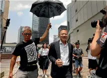  ?? AP ?? Occupy Central leader Benny Tai, front right, is accompanie­d by a supporter as he leaves High Court in Hong Kong. Tai, a top opposition leader imprisoned on public disorder charges, was released on bail on Thursday as Hong Kong’s government attempts to quell a protest movement that has paralysed parts of the territory.