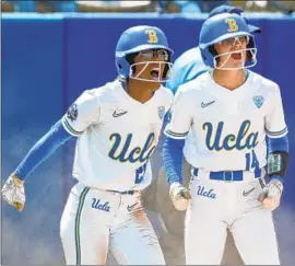  ?? Alonzo Adams Associated Press ?? ANNA VINES, left, and Kelli Godin celebrate after scoring runs during the fourth inning of UCLA’s 8-0 victory against Florida on Sunday.