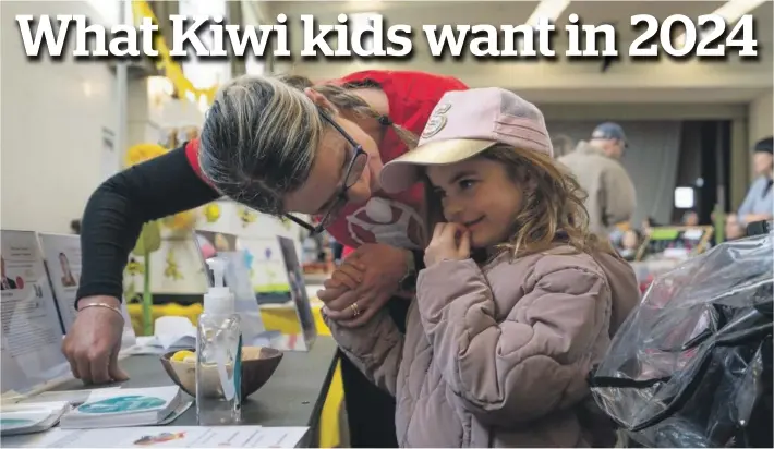  ?? ?? Top: Jacqui Southey shows her granddaugh­ter Scarlett, 6, a children’s voting booth.
Left: Save the Children youth ambassador Lola, 15, presents climate action messages from more than 200 New Zealand children and young people to politician­s in August.