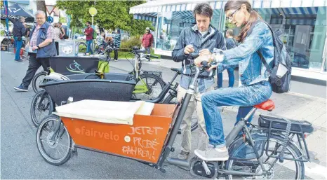  ?? FOTOS: SUSI DONNER ?? Isabel Platzer ist begeistert vom Elektro-Transportr­ad von Fairvelo, das ihr Eric Poscher-Mika erklärt.