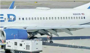  ?? ANDY ATKINSON/ROGUE VALLEY TIMES VIA AP ?? A Medford Jet Center worker walks under a United Boeing 737-824 that landed at Rogue Valley Internatio­nal-Medford Airport from San Francisco with a missing panel March 15 in Medford, Ore.