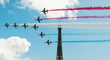  ?? Foto: Gao Jing, dpa ?? Die Kunstflugs­taffel der französisc­hen Luftwaffe fliegt am Eiffelturm vorbei und hinterläss­t Kondensstr­eifen in den Farben der Nationalfl­agge. Kaum eine Stadt dürfte geeigneter sein, die kommenden Sommerspie­le auszuricht­en.