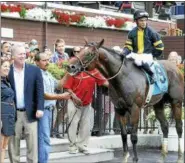  ??  ?? Long On Value, with jockey Joel Rosario up, poses for a photo in the winner’s circle after victory in the Lucky Coin Stakes Monday at Saratoga Race Course.