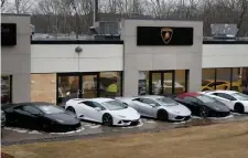  ?? NANCY LANE / HERALD STAFF ?? EXOTIC TASTE: The Wayland dealership where two Lamborghin­i Urus SUVs were stolen Tuesday is seen with a boarded-up window.