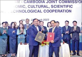  ?? MFAIC ?? Foreign minister Prak Sokhonn (left) and his Vietnamese counterpar­t exchange a memorandum of understand­ing (MoU) on March 21.