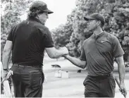  ?? Sam Greenwood / Getty Images ?? Even at their age, when Phil Mickelson, left, and Tiger Woods cross golfing paths, it’s still big news.