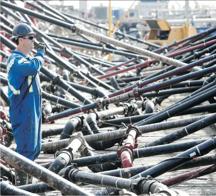  ?? NEXEN ?? A Nexen contractor works at the company’s shale gas drilling site in northeaste­rn British Columbia. The plunging price of crude is taking its toll on hedging contracts. “Now that it’s trading under US$50, not many people are rushing to hedge,” said...