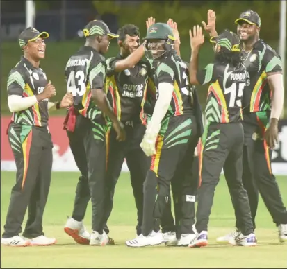  ??  ?? The Guyana Jaguars players celebrate the fall of a wicket.