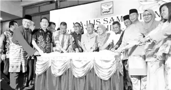  ??  ?? Pairin, Maximus and other PBS Supreme Council members and members cutting the Hari Raya cake during the gathering in Kota Kinabalu on Saturday.