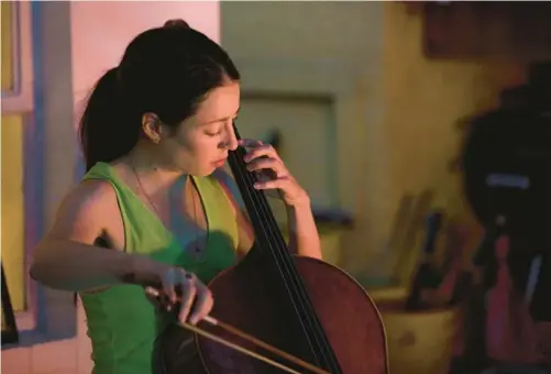  ?? JAMES C. SVEHLA/CHICAGO TRIBUNE ?? Cellist Lia Kohl plays with one of her groups, Honestly Same, as part of Compound Yellow’s Side Yard Sounds series in Oak Park on June 24.