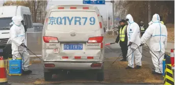  ?? NG HAN GUAN/THE ASSOCIATED PRESS FILES ?? Workers disinfect vehicles in response to an African swine fever outbreak on the outskirts of Beijing last November.