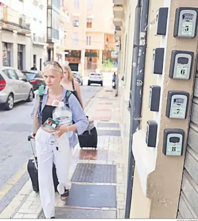  ?? JAVIER ALBIÑANA ?? Una turista pasa ante las cajas donde las casas turísticas dejan sus llaves a los clientes.