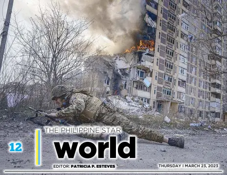  ?? AP ?? A Ukrainian police officer takes cover in front of a burning building that was hit in a Russian airstrike in Avdiivka on Monday amid Russia’s invasion of Ukraine.