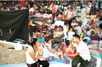  ??  ?? A family from Honduras eats in an improvised shelter during a break in their journey towards the United States, in Huixtla, Mexico. — Reuters photo