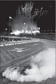  ??  ?? SMILES FOR KYLE: Kyle Busch celebrates winning the NASCAR Sprint Cup Series race at Richmond Internatio­nal Raceway as fireworks go off in the background Saturday in Richmond, Va. Busch claimed both the Nationwide and Sprint Cup races over the weekend.