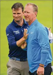  ?? STUART FRANKLIN / GETTY IMAGES ?? Zach Johnson (left) embraces David Duval during the first round of the 148th British Open held on the Dunluce Links at Royal Portrush Golf Club on Thursday. Duval shot a 91 Thursday.
